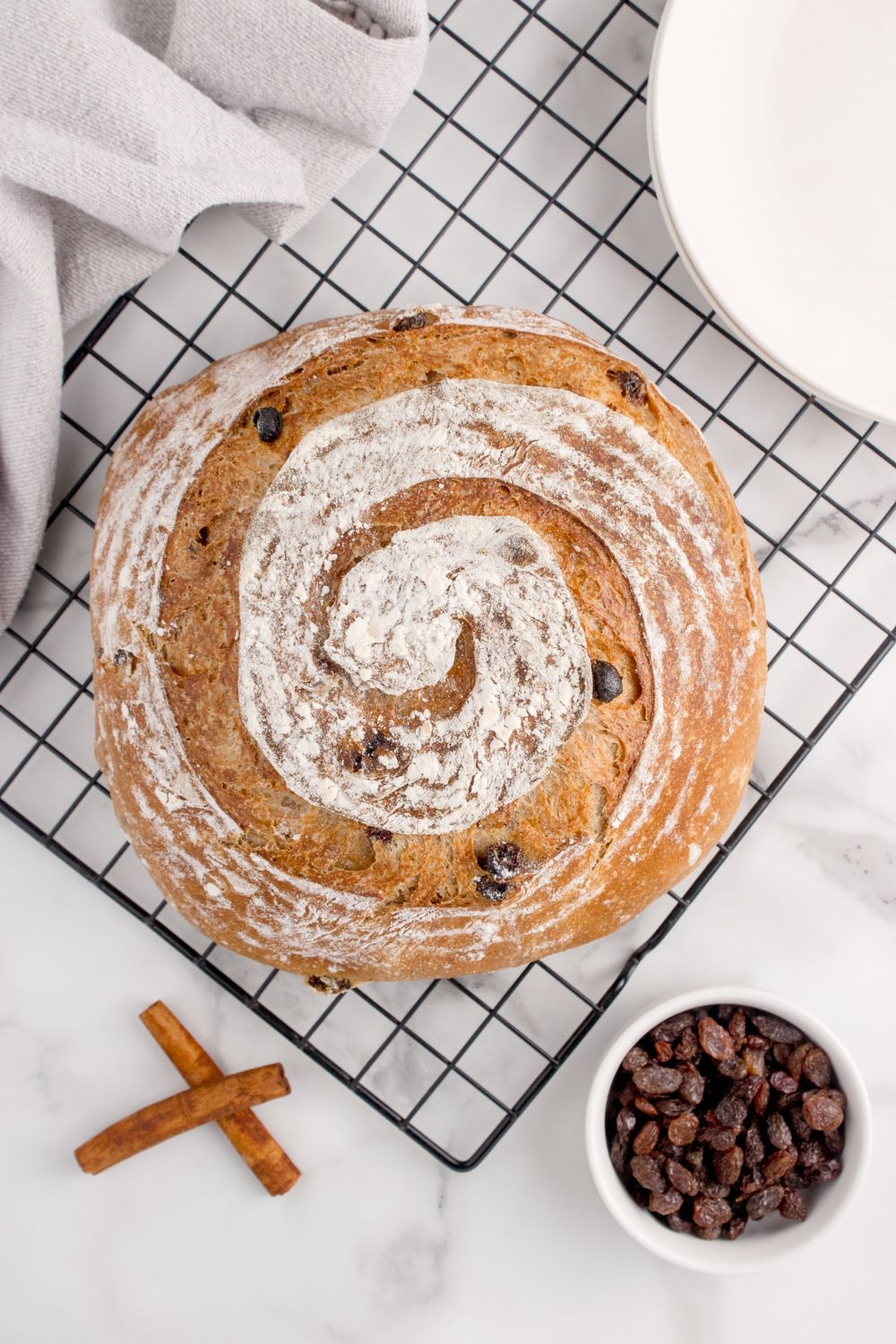 baked cinnamon raisin bread on cooling rack sitting on table