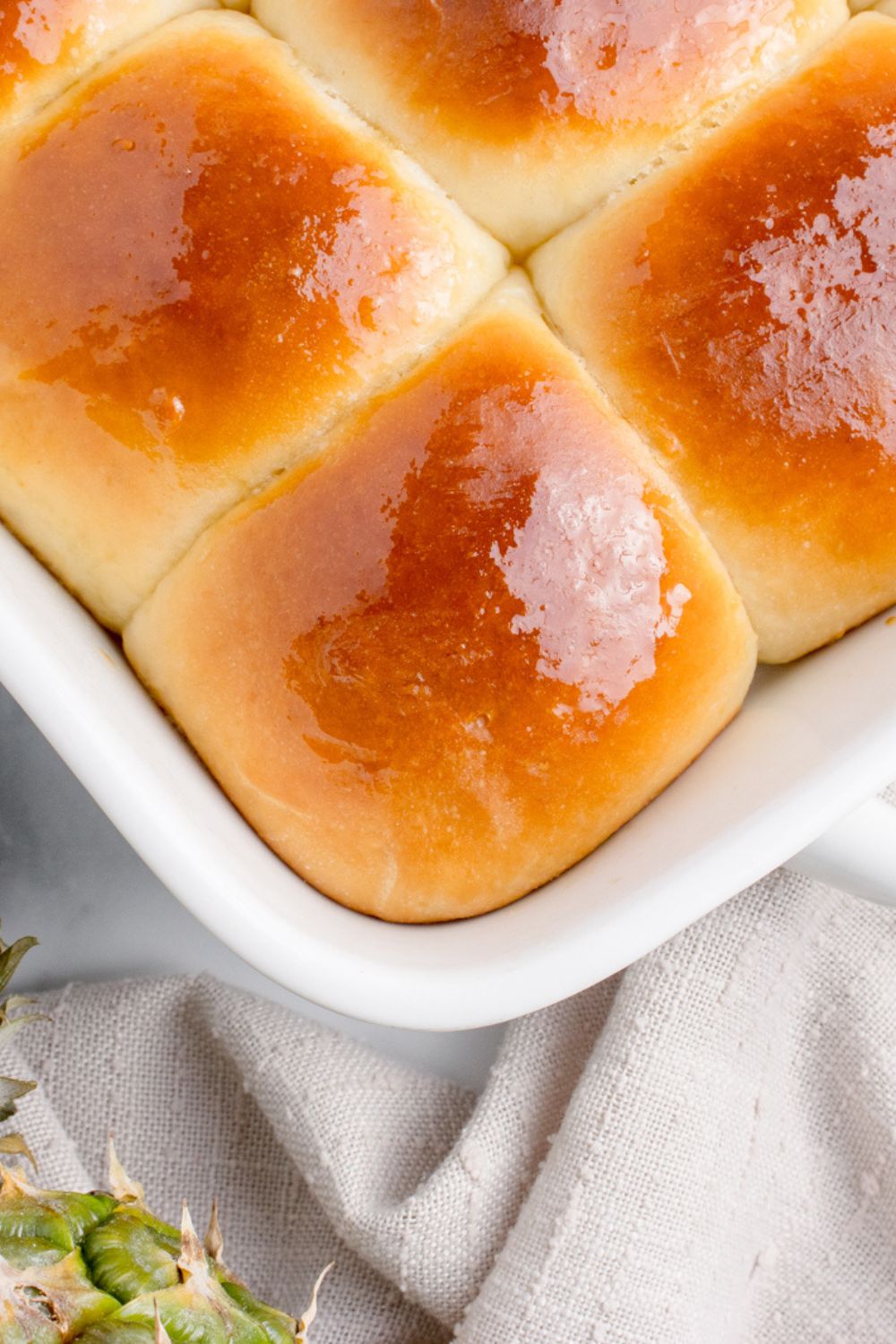 hawaiian sweet rolls in a pan that are buttered
