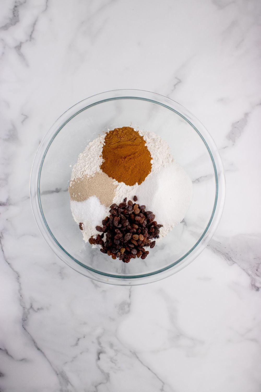 spices and raisins in a bowl for cinnamon raisin bread on counter