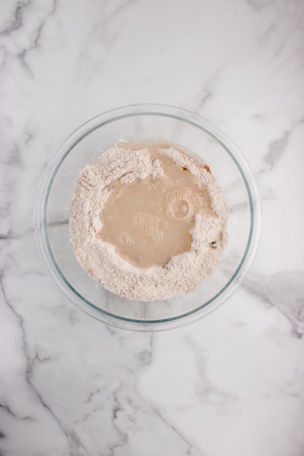 flour and yeast mixture in a glass bowl for the cinnamon raisin bread