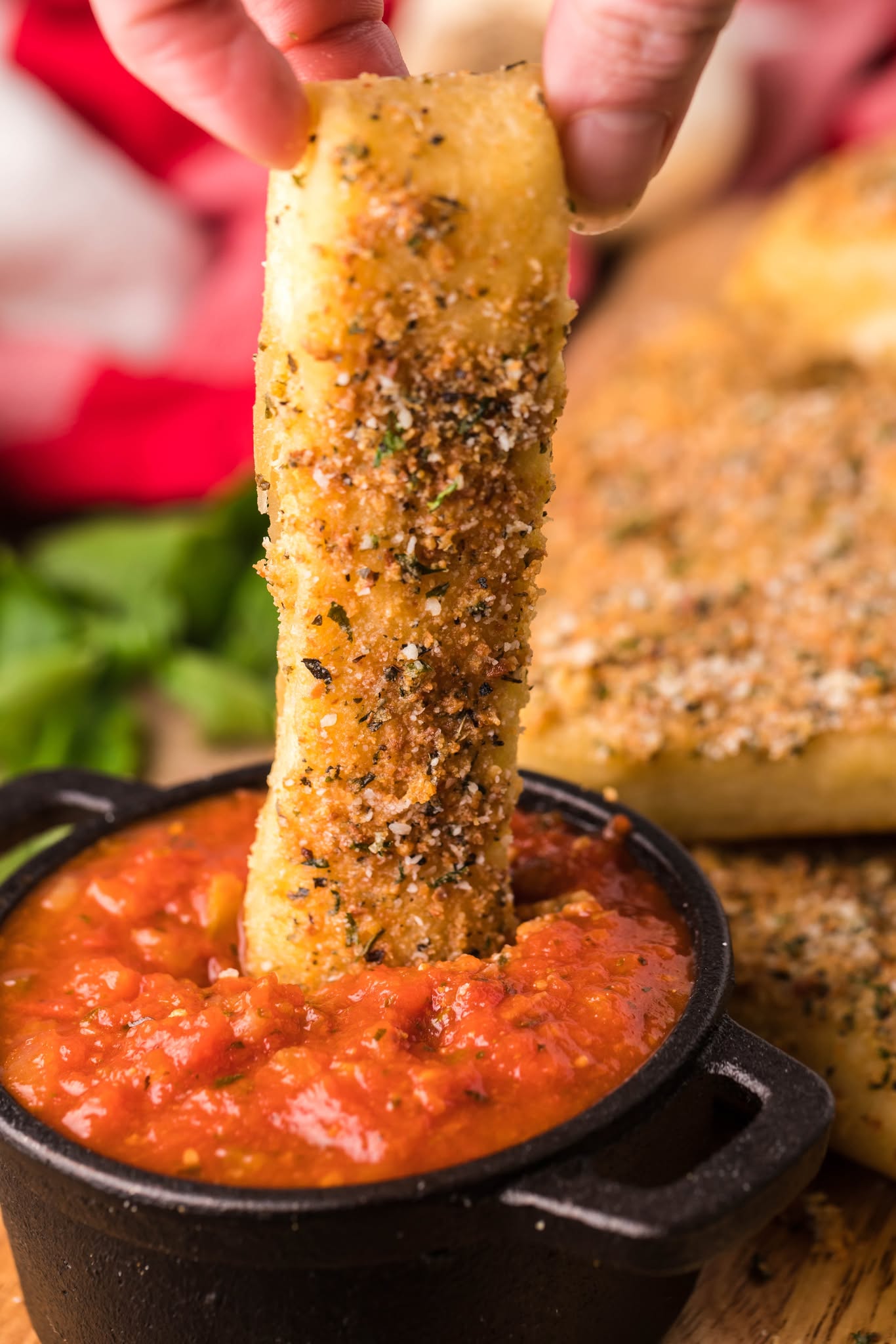 Copycat Pizza Hut Breadstick being dipped into a cup of marinara sauce