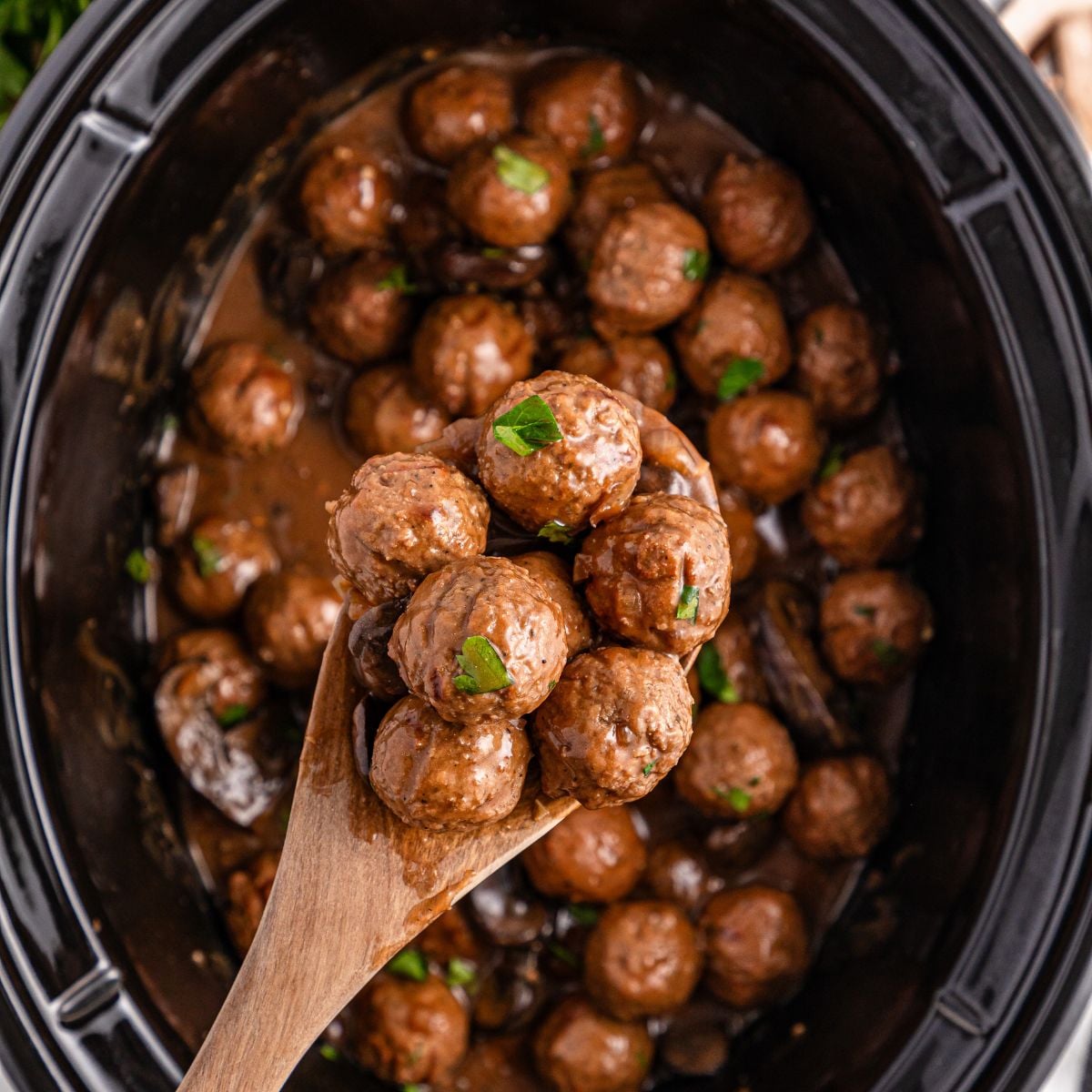 Crock Pot Salisbury Steak Meatballs in crock pot with a spoon with a few meatballs in it above crock pot