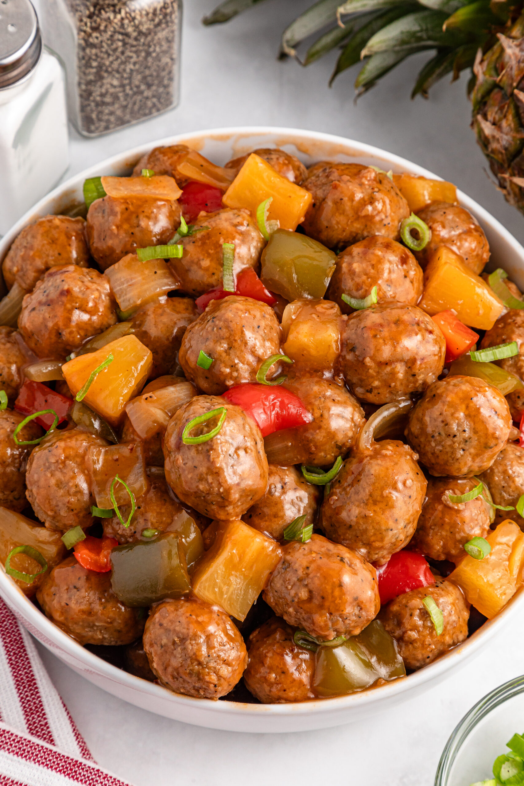 crock pot sweet and sour meatballs in a large white serving bowl