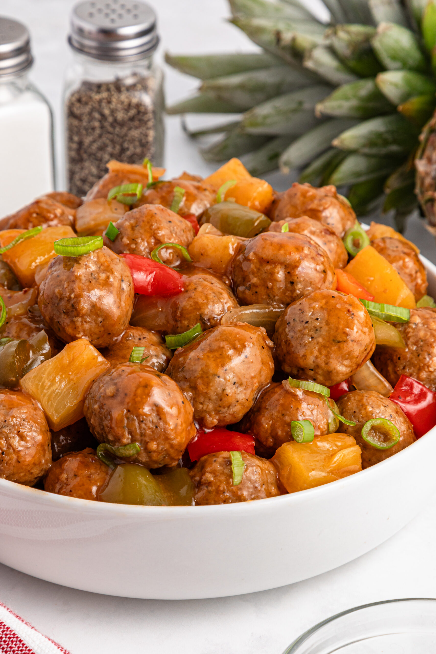 Crock Pot Sweet And Sour Meatballs piled on a bed of rice on plate