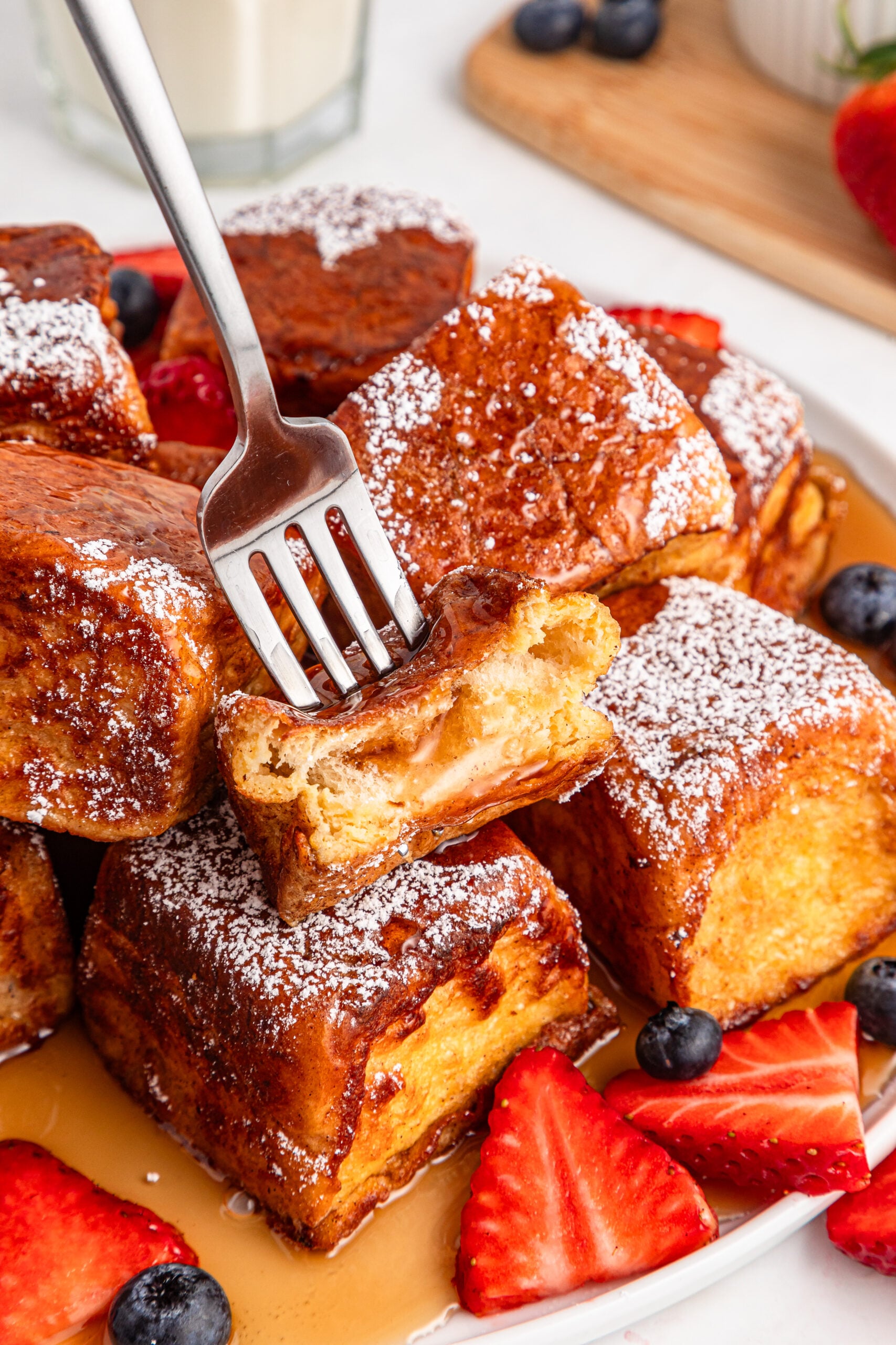 syrup on top of the Hawaiian Roll French Toast with a fork lifting up a piece