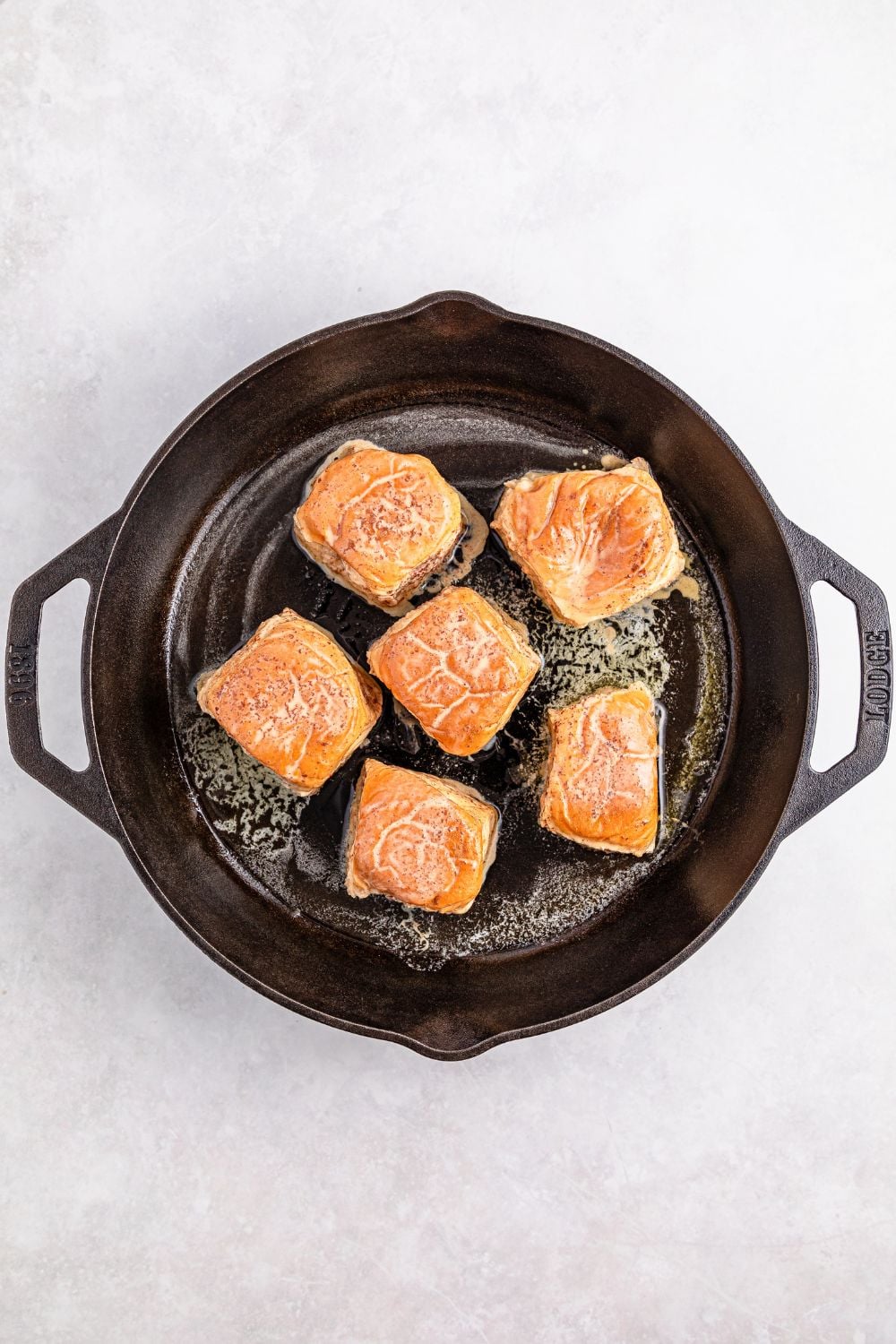 cooking up Hawaiian Roll French Toast in a cast iron skillet 