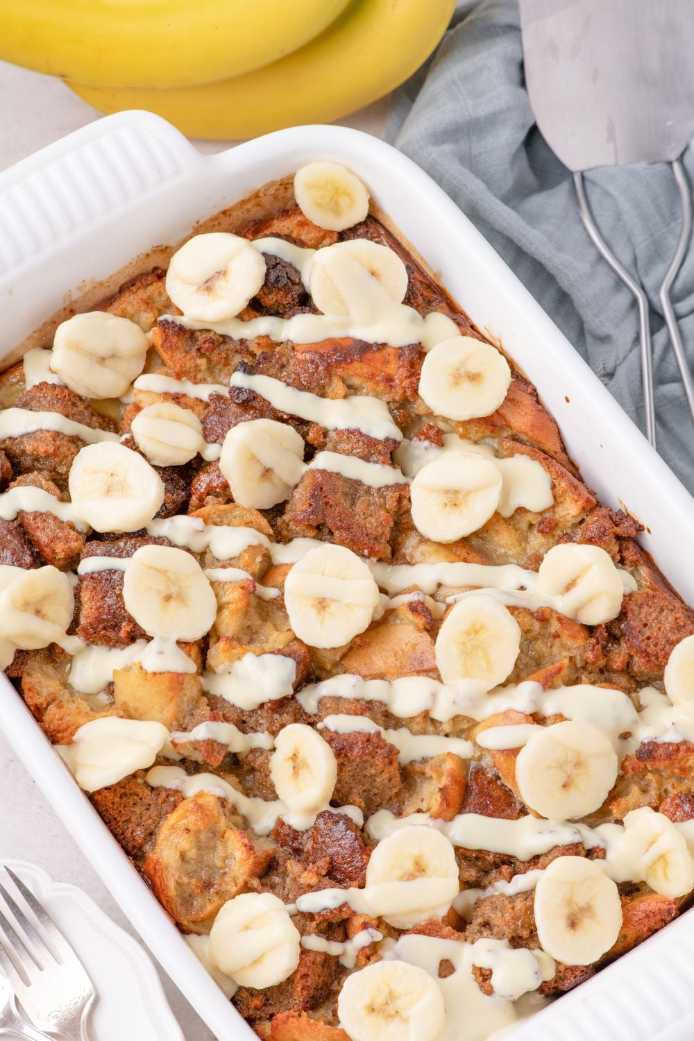 Banana Bread Pudding in a casserole dish topped with sliced bananas