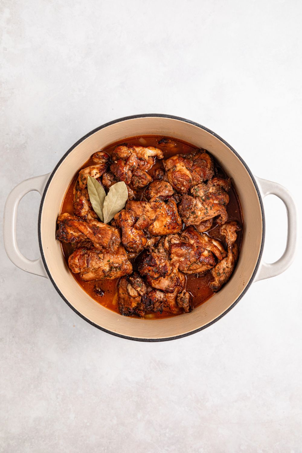 Jamaican Brown Stew Chicken in Dutch oven ready to cook on stovetop