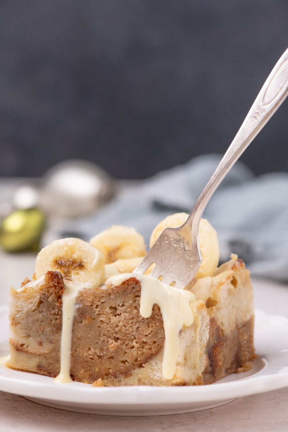 slice of Banana Bread Pudding on plate with a fork poked into it