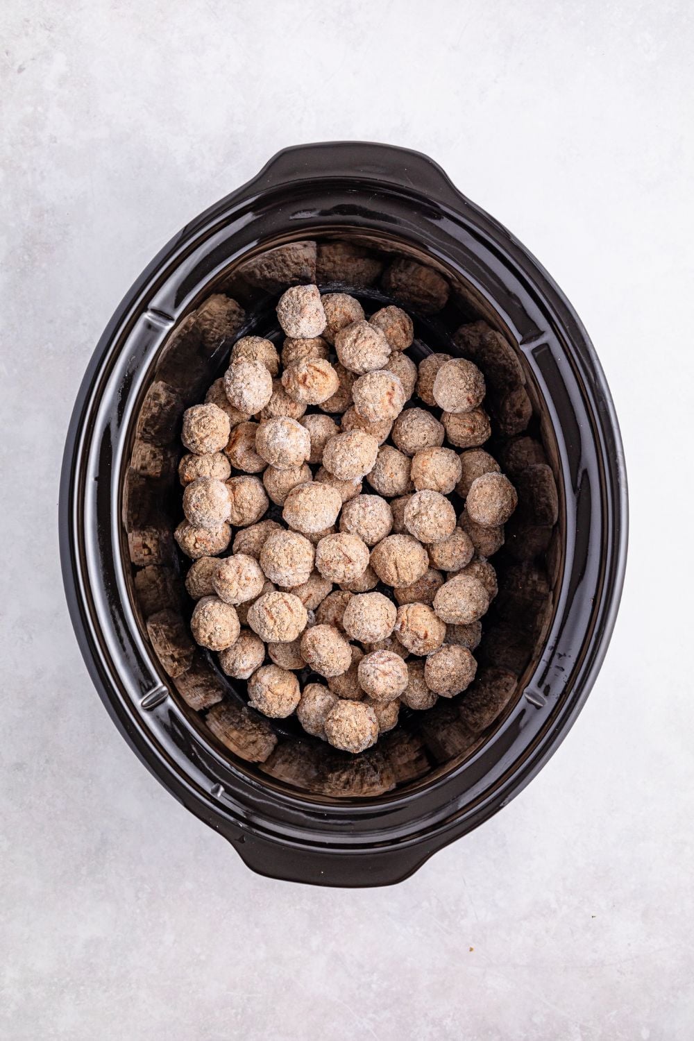 frozen meatballs in a crockpot sitting on a table