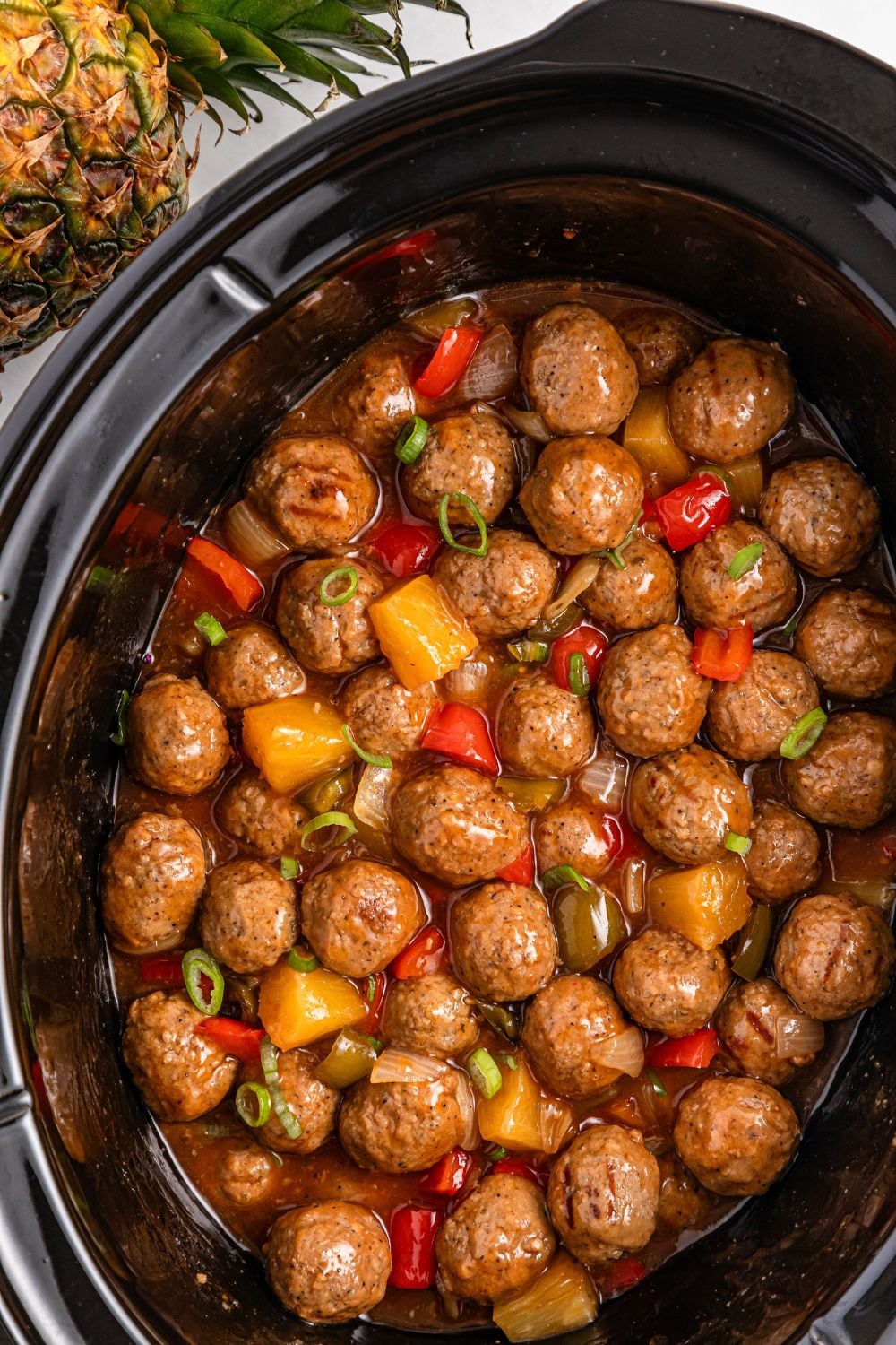 sweet and sour meatballs in a slow cooker on table
