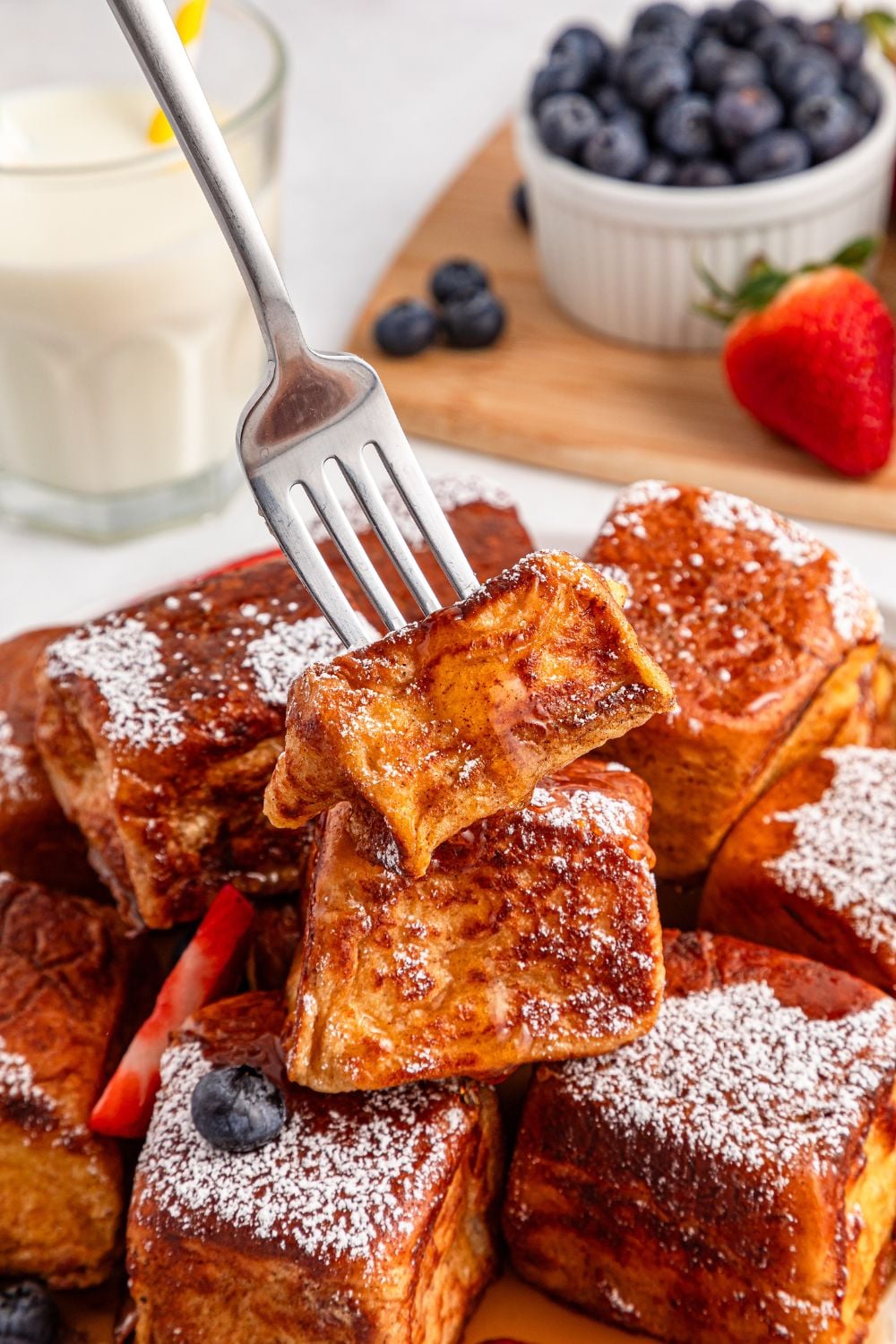 fork poking in one of the Hawaiian Roll French Toast on a plate 