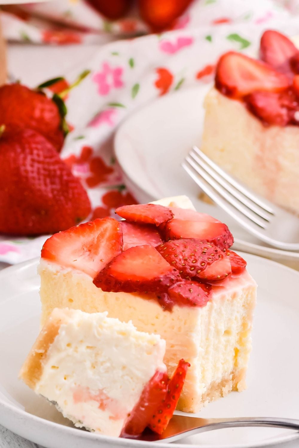 slice of cheesecake on a plate with a fork and some cheesecake on the fork 