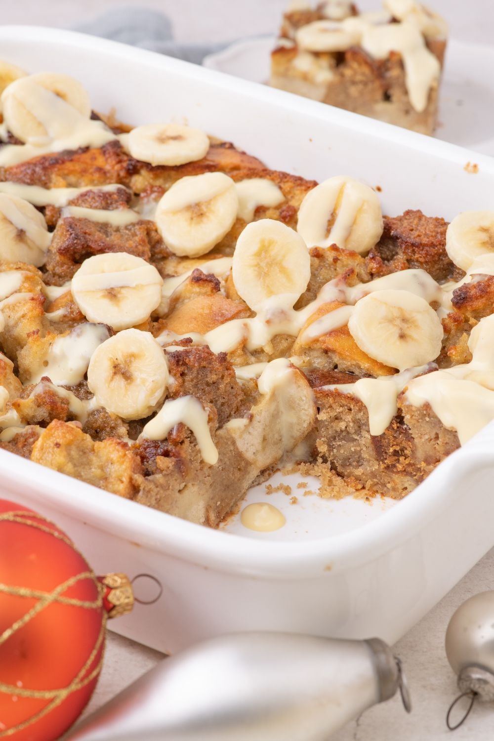 side view of Banana Bread Pudding in pan with a slice taken out of it