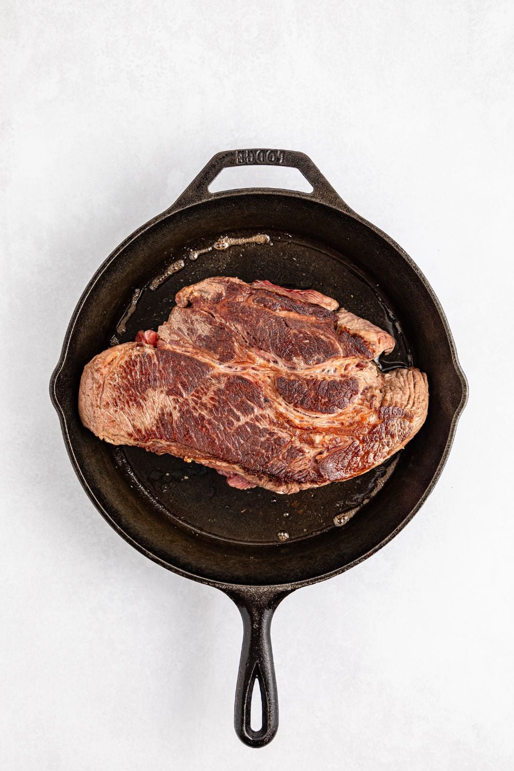 pot roast being seared in a skillet