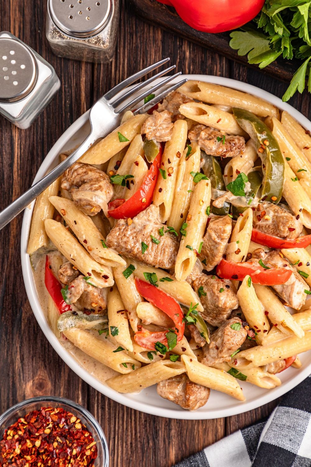 overhead shot of Rasta Pasta on a plate with salt and pepper shakers and veggies around plate on table