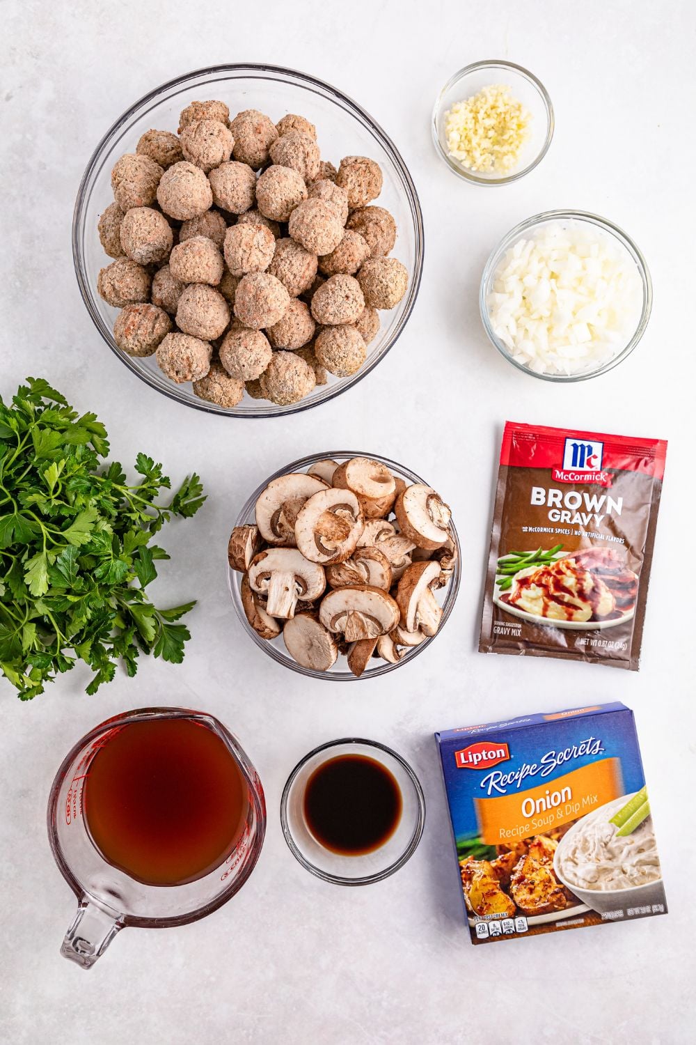 Crock Pot Salisbury Steak Meatball ingredients on a white table in single serve bowls to show each ingredient