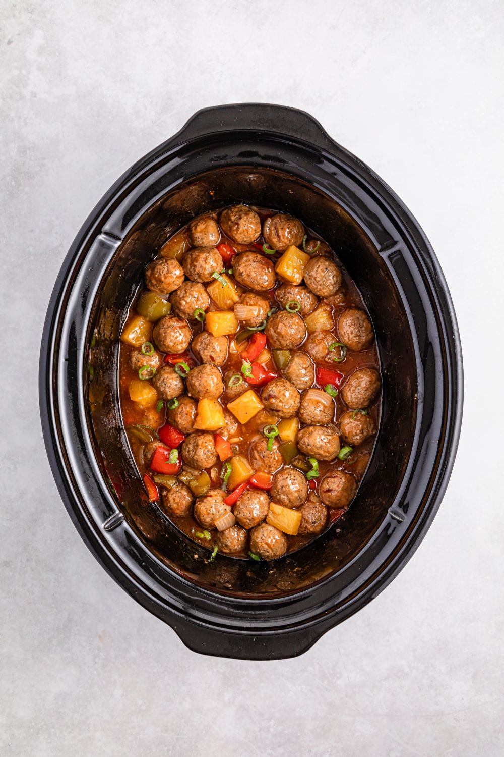 Crock Pot Sweet And Sour Meatballs mixed up in a crockpot