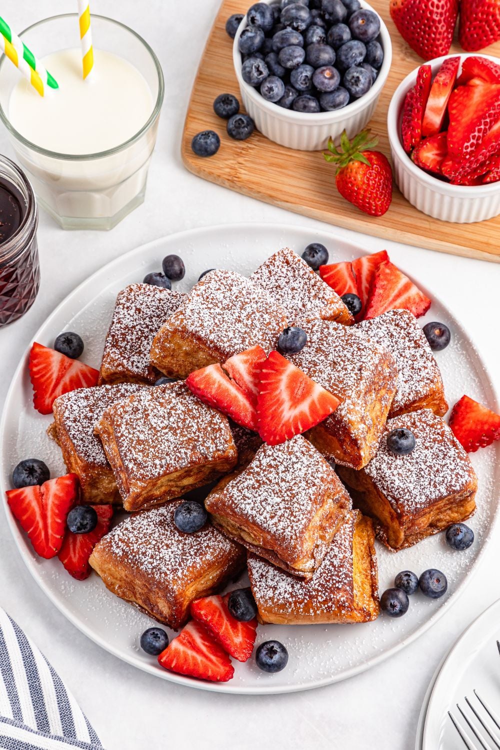 Hawaiian Roll French Toast pieces on a plate with fruit around it 