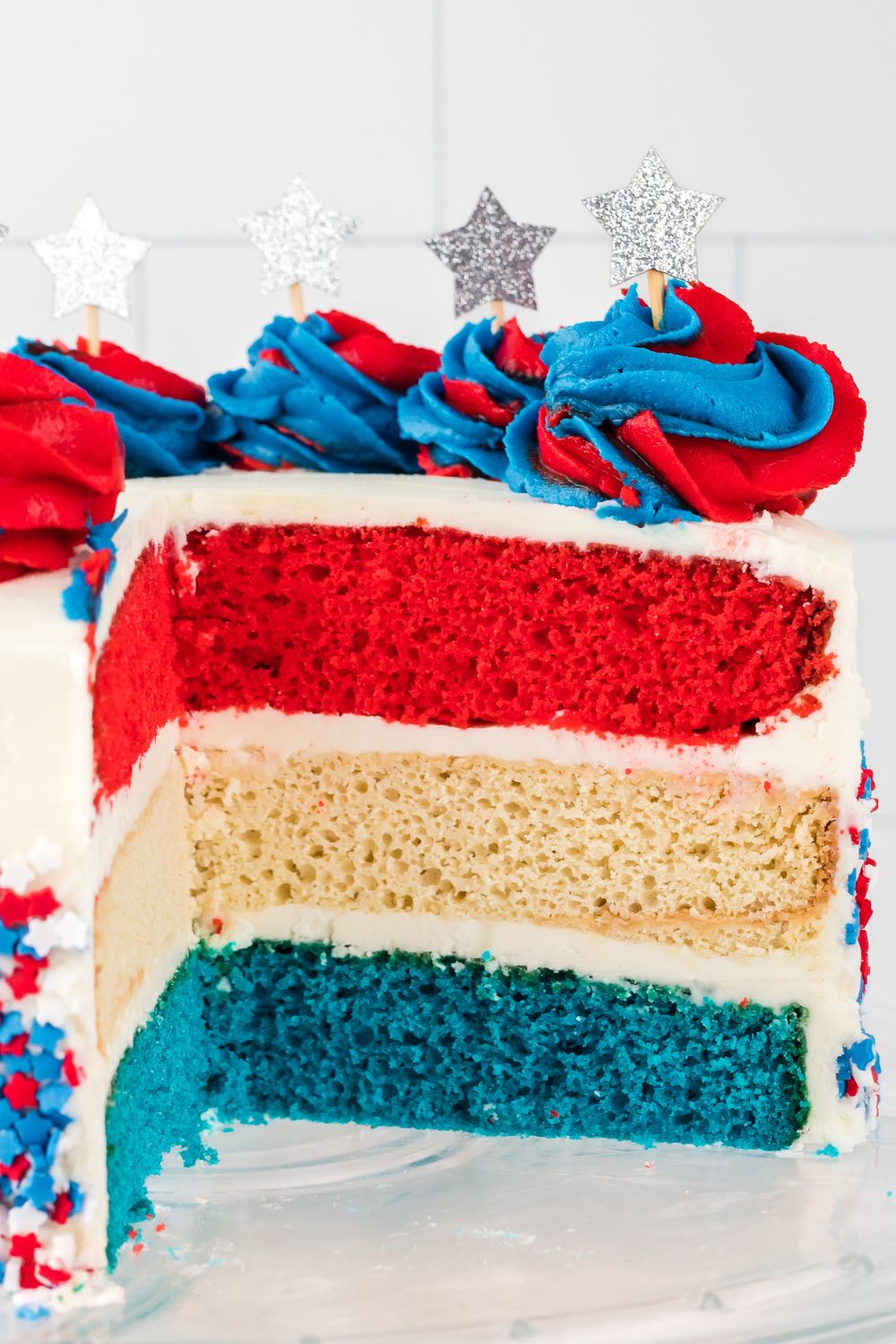 American Flag Cake cut open to see the colors of layers that is frosted 