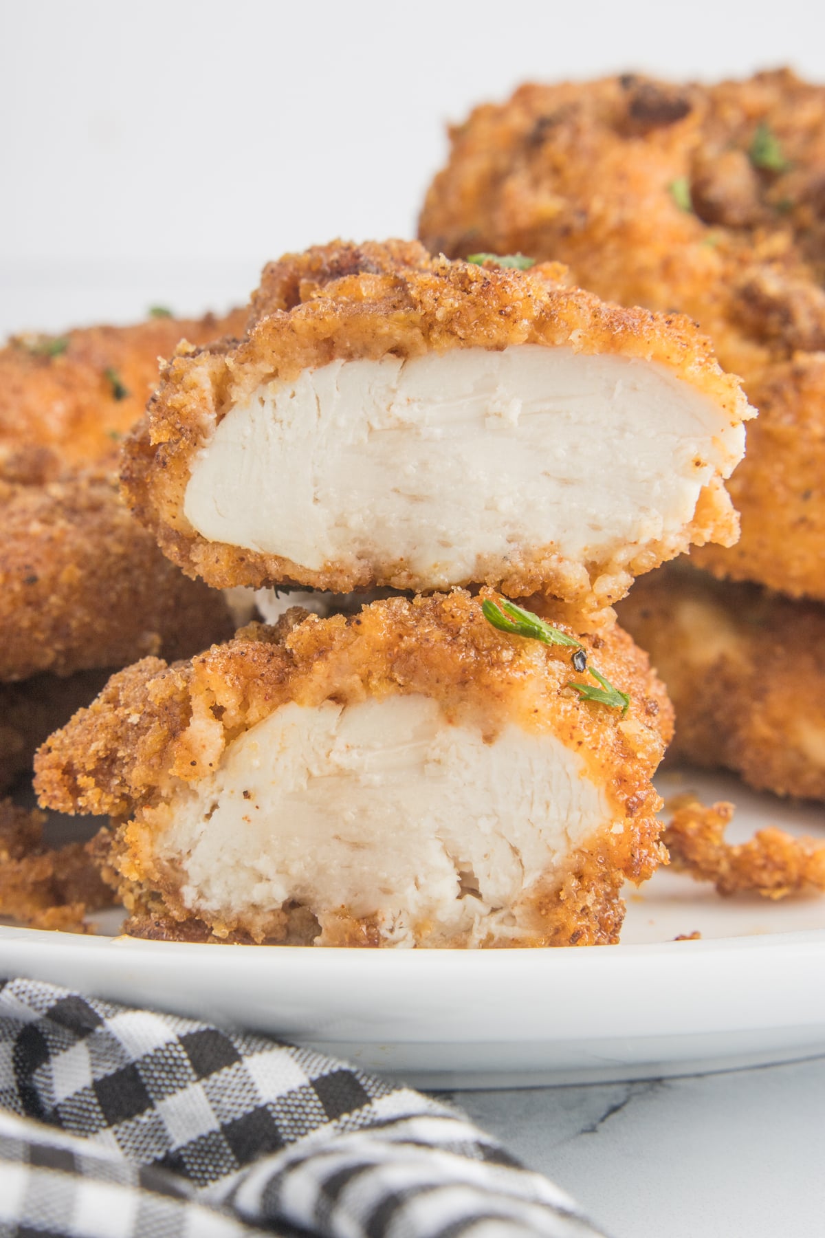 Air Fryer Chicken Tenders cut open on a white plate showing the cooked inside