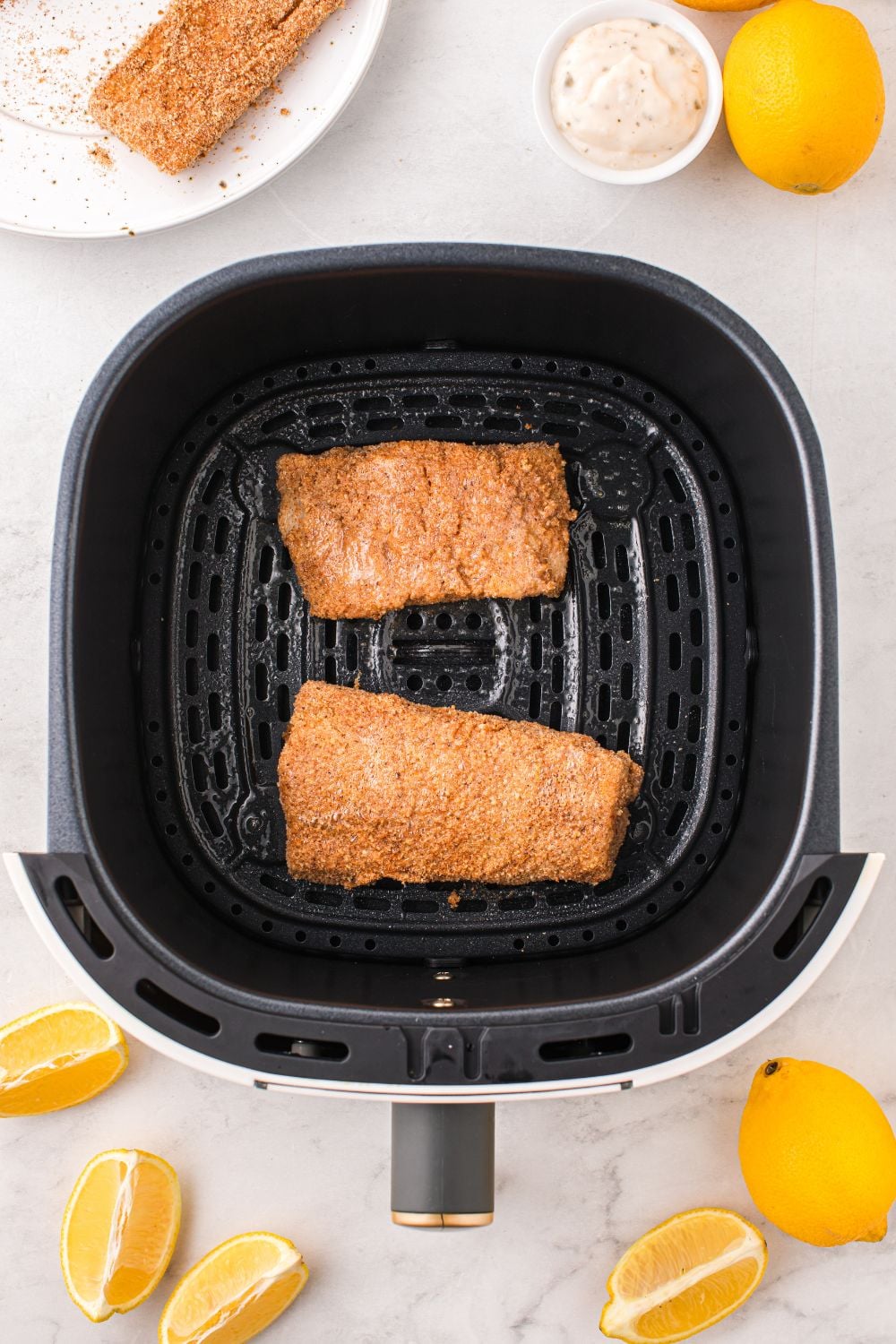 raw breaded fish in air fryer basket