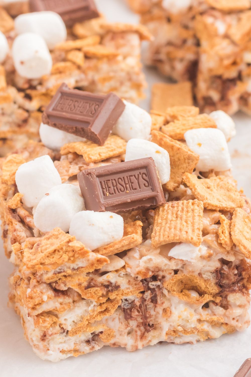 close up of S’mores Rice Krispy Treats on table showing all the chocolate and marshmallows on top 