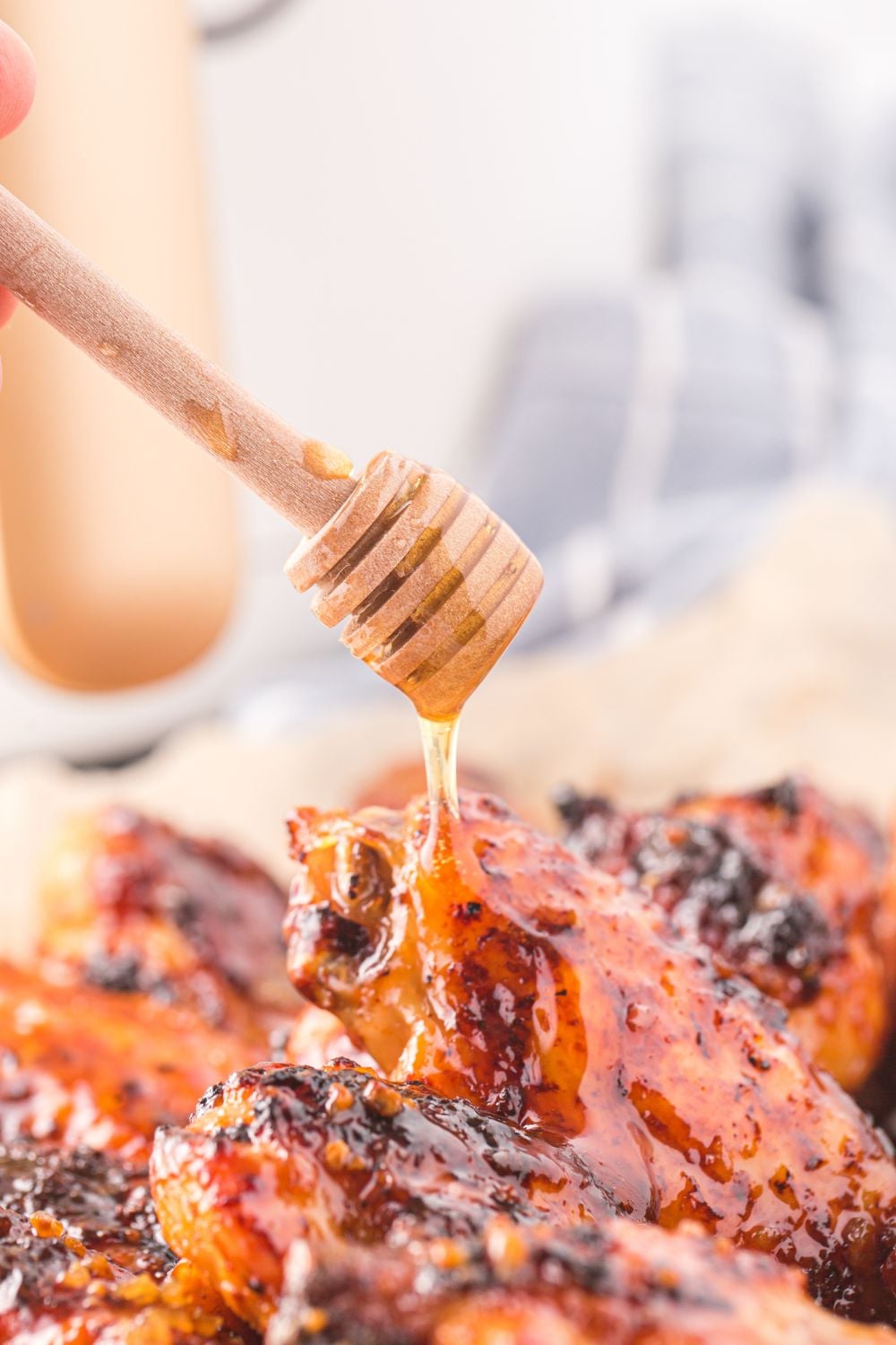 Honey Chicken Wings on plate with honey being drizzled on top 