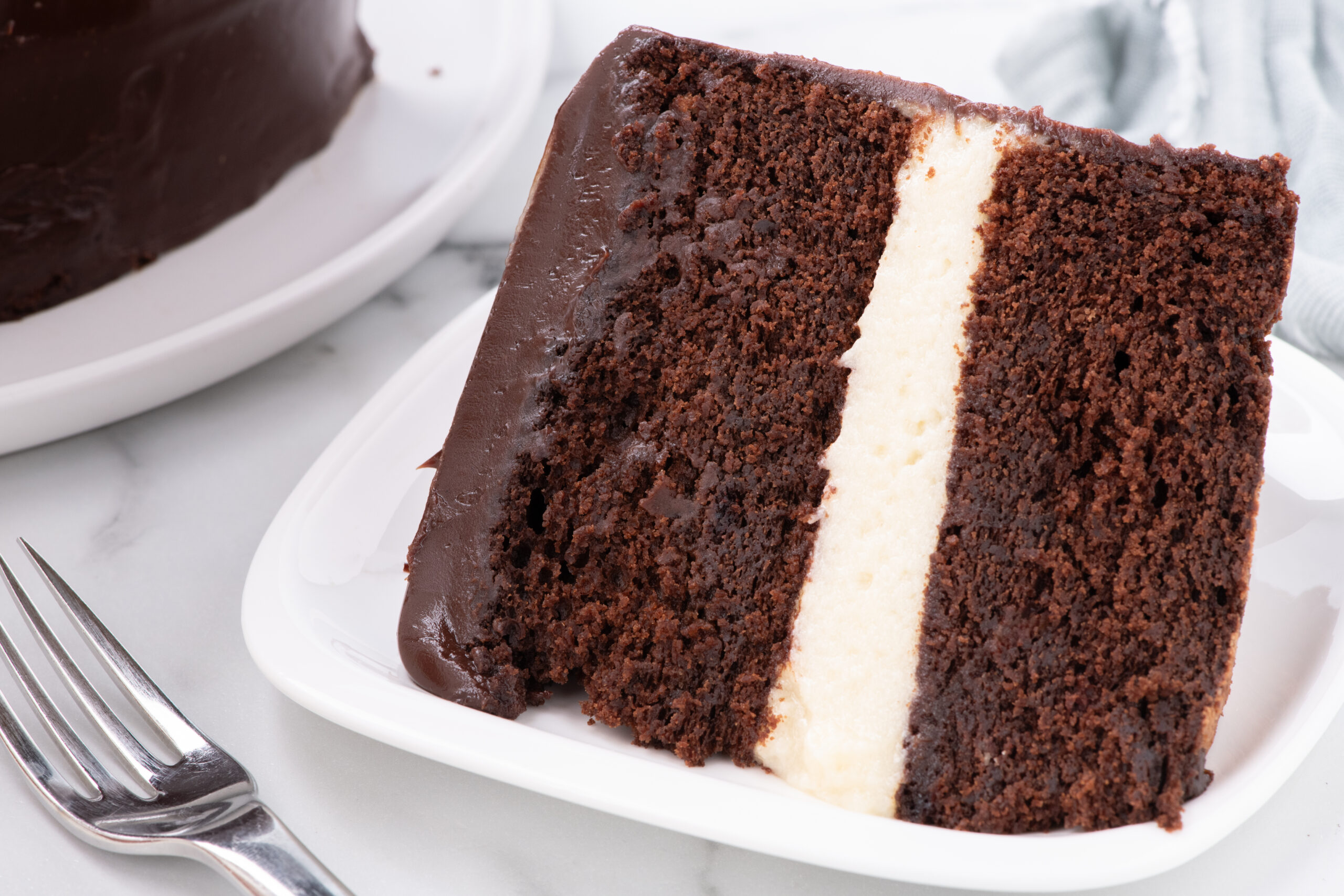 side view of Slice of Ding Dong Cake on a white plate with a pork on the side