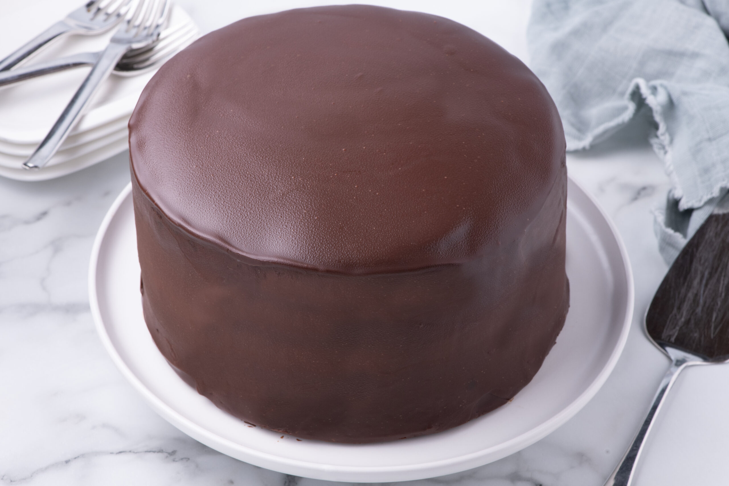Whole uncut Ding Dong Cake on a white cake stand