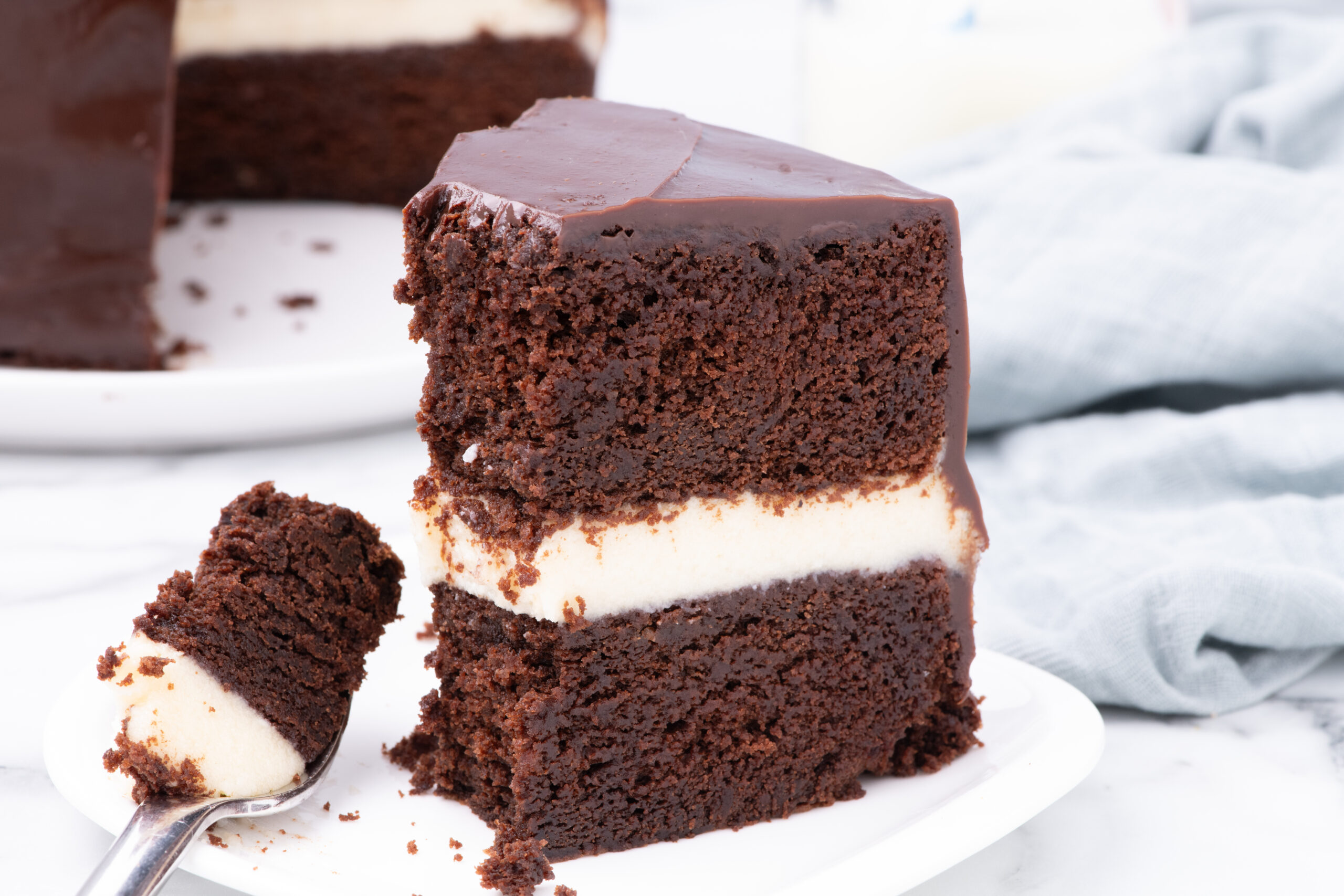 Slice of Ding Dong Cake on a white plate with a fork holding a bite