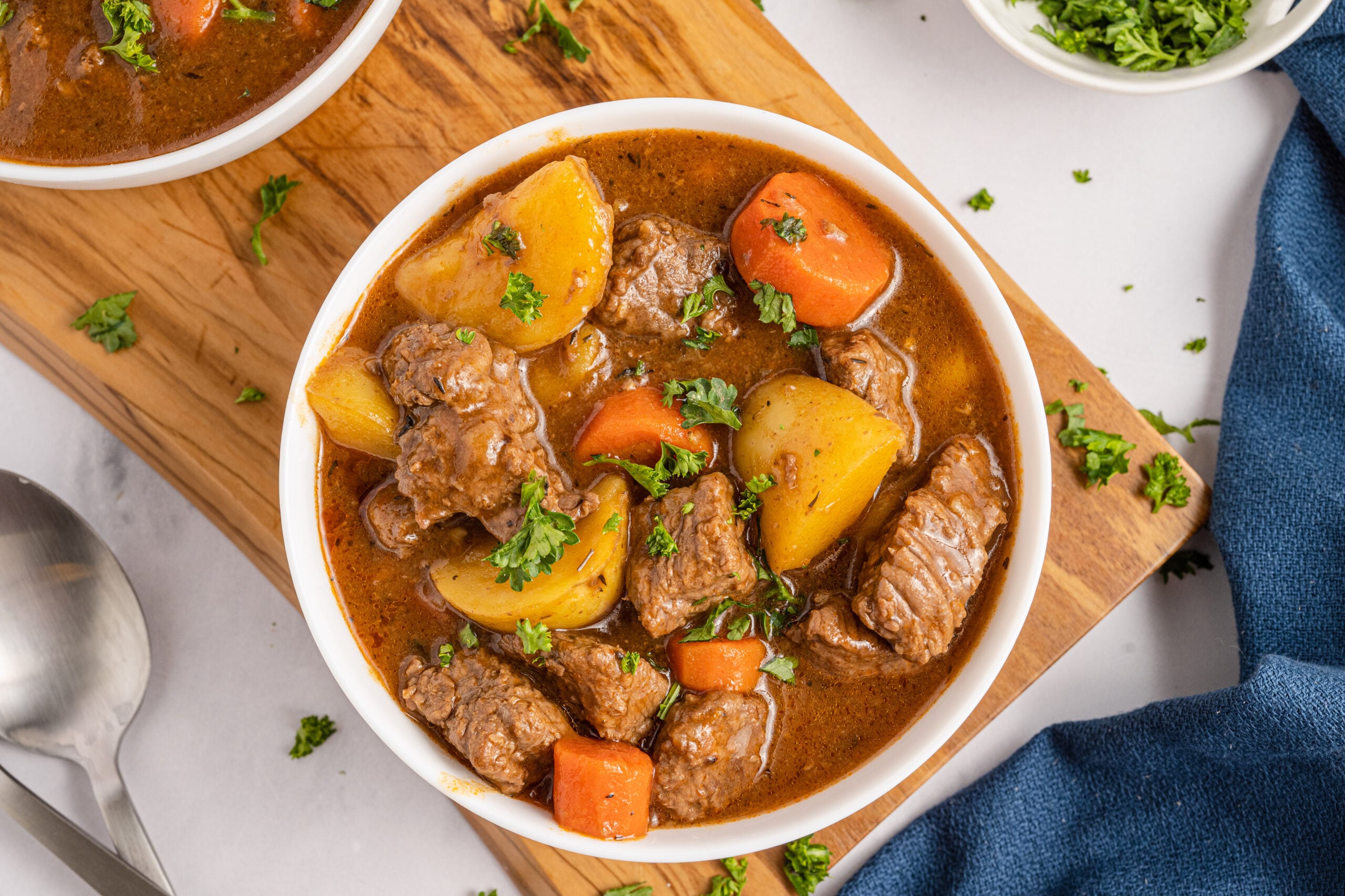 Overhead shot of Two bowls of Irish stew sitting on a wooden board