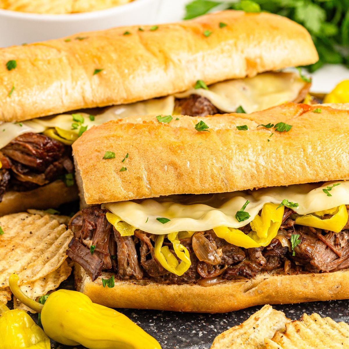 Mississippi Pot Roast Sandwiches on table with chips on the side 
