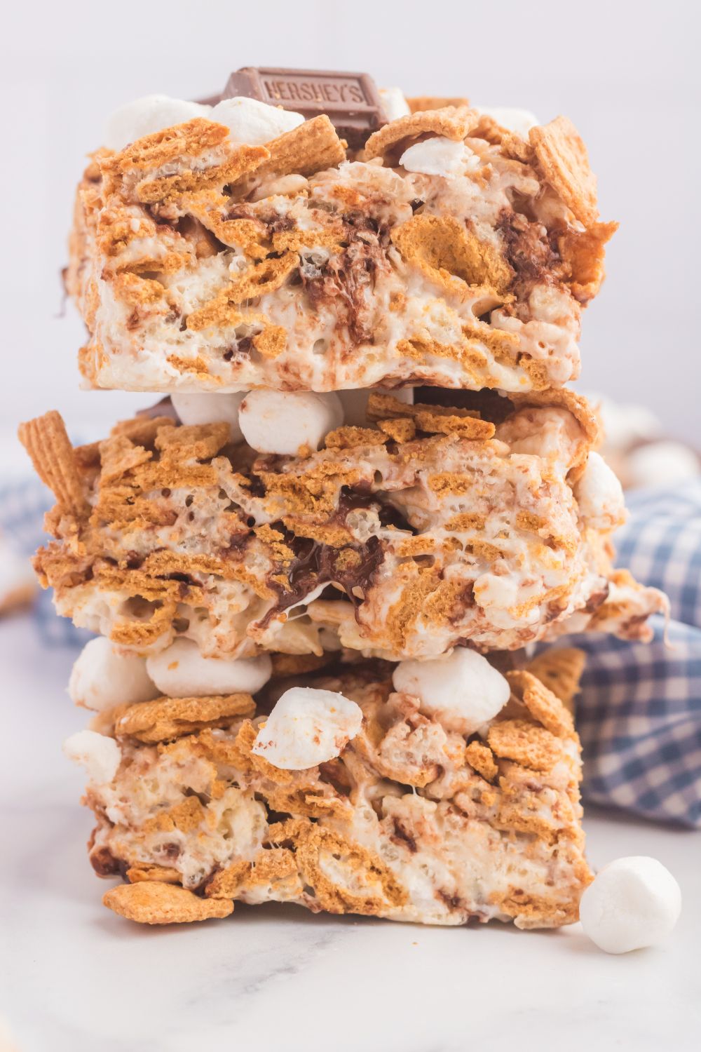 S’mores Rice Krispy Treats stacked on top of one another on table 