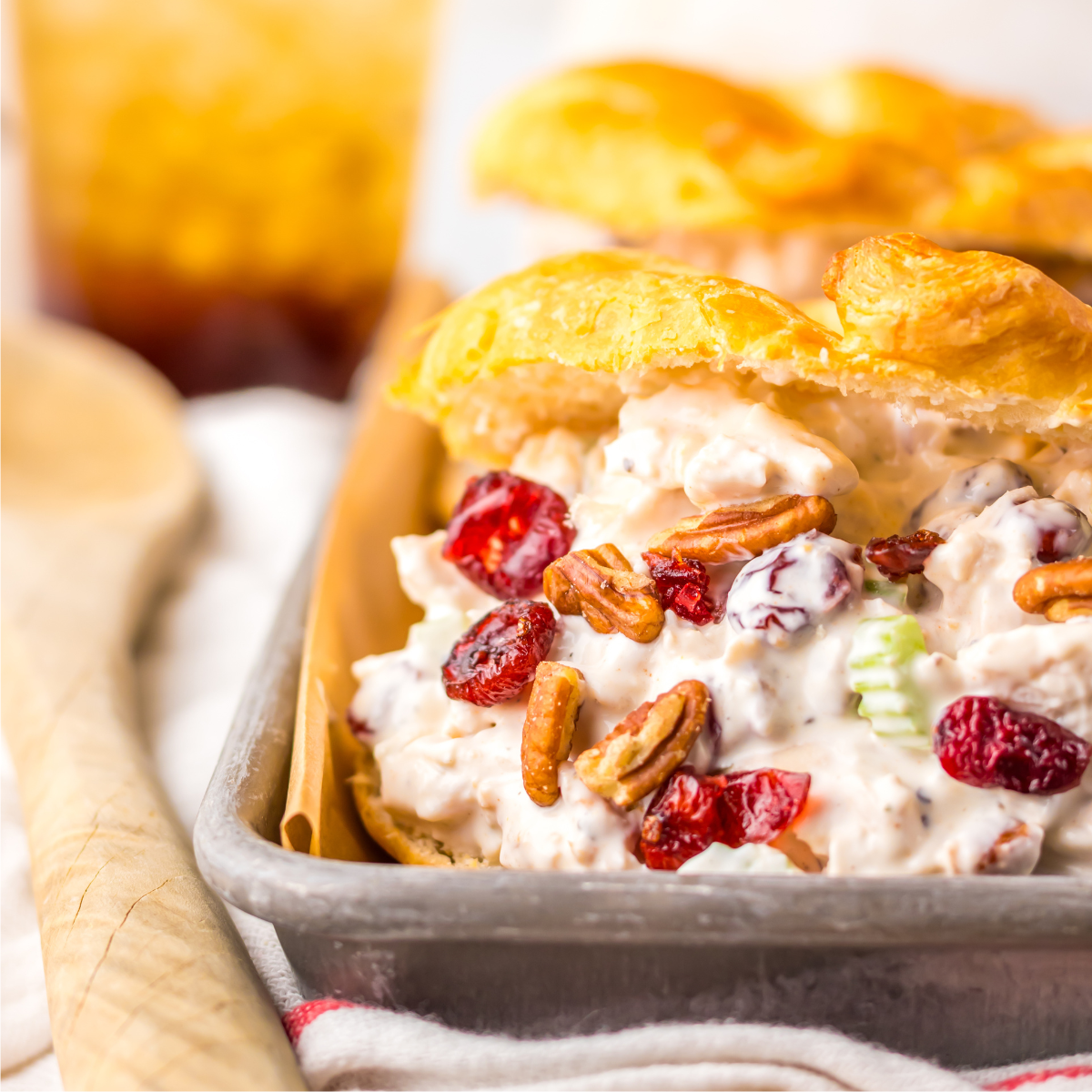 Close up of the chicken salad croissant filling topped with cranberries and pecans.