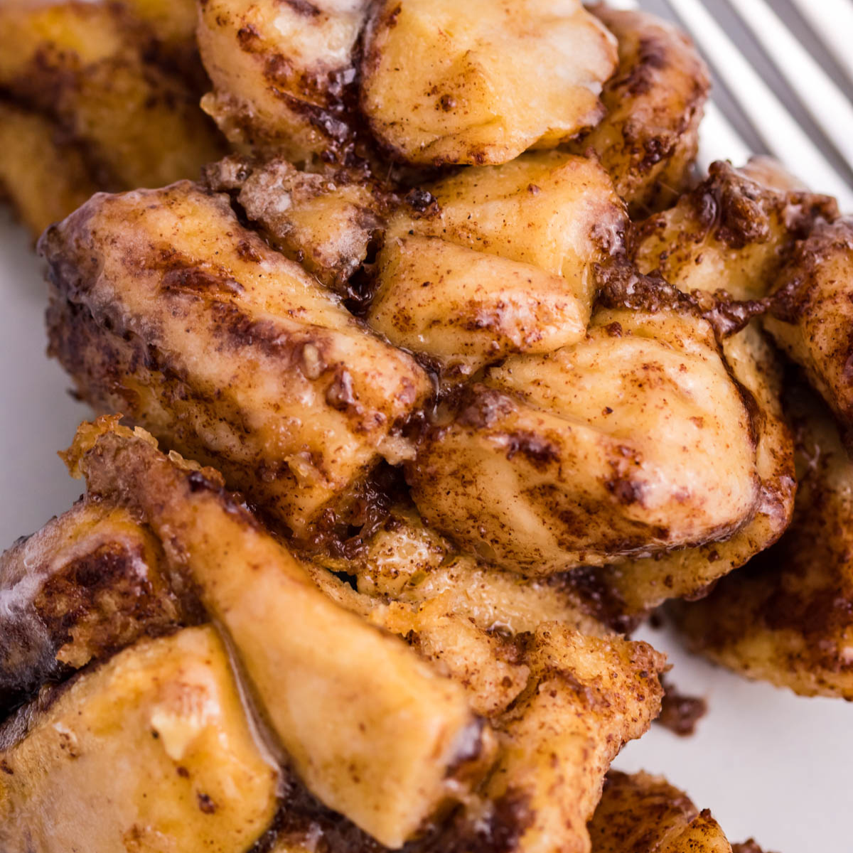 Up close view of the cinnamon sugar on the casserole on a white plate.