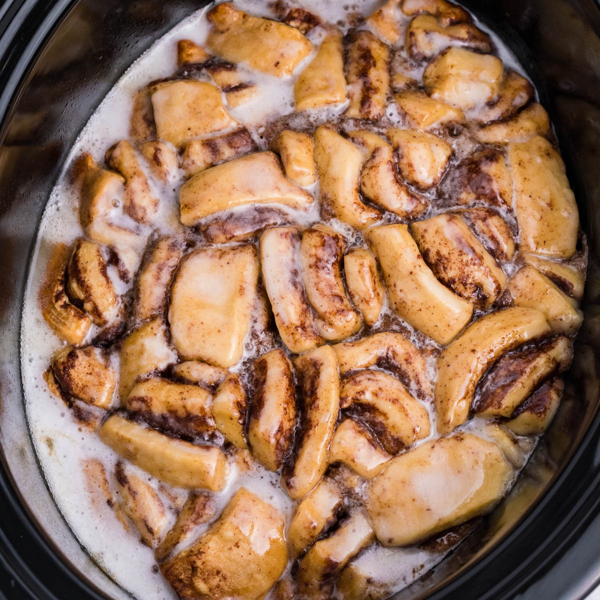Overhead view of Crock Pot Cinnamon Roll Casserole in a black crock pot insert