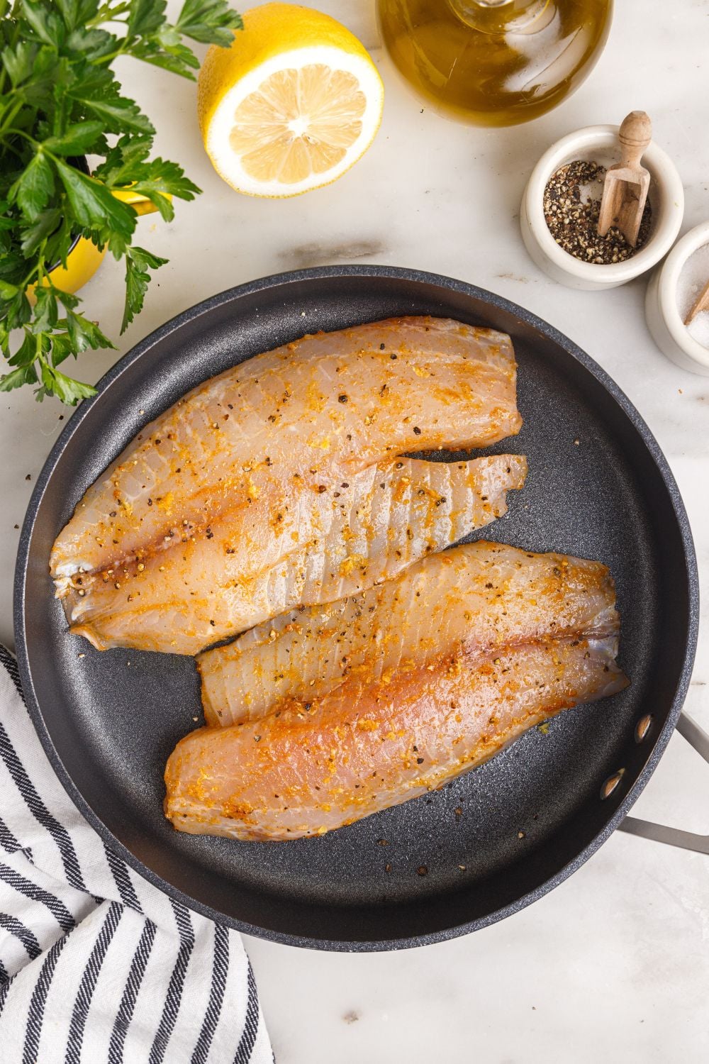 seasoned tilapia in pan, raw.