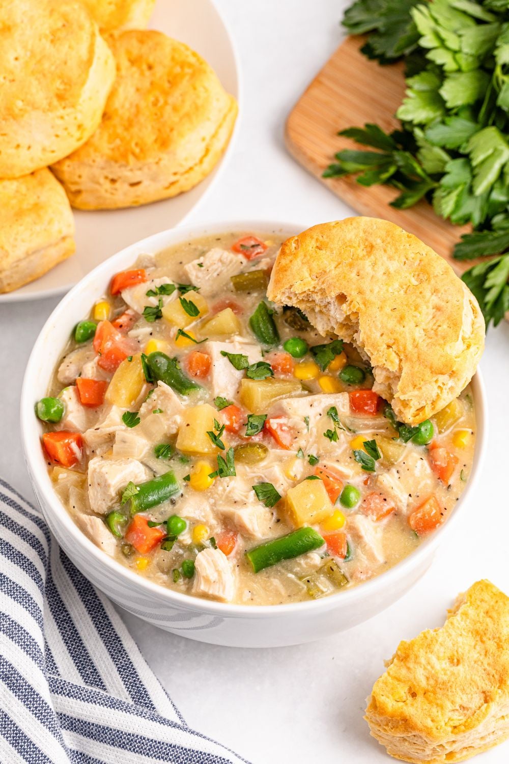 Slow Cooker Chicken Pot Pie in a bowl with biscuits on the side 