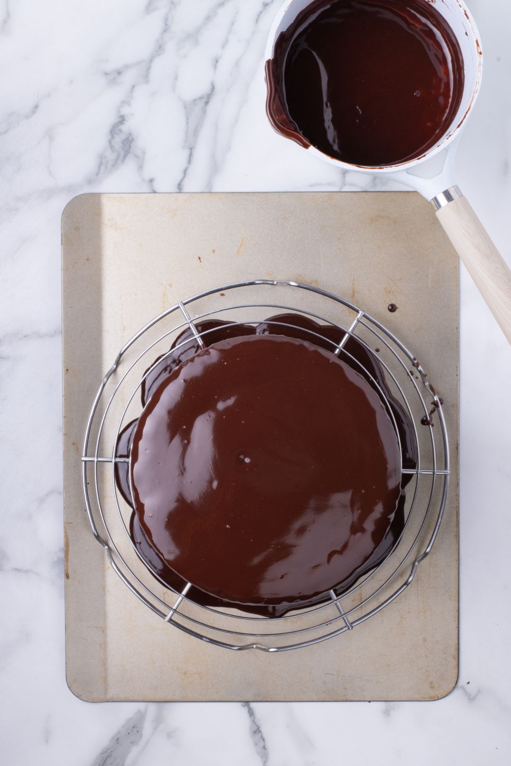 Ding Dong Cake sitting on a tray with chocolate ganache dripping off it