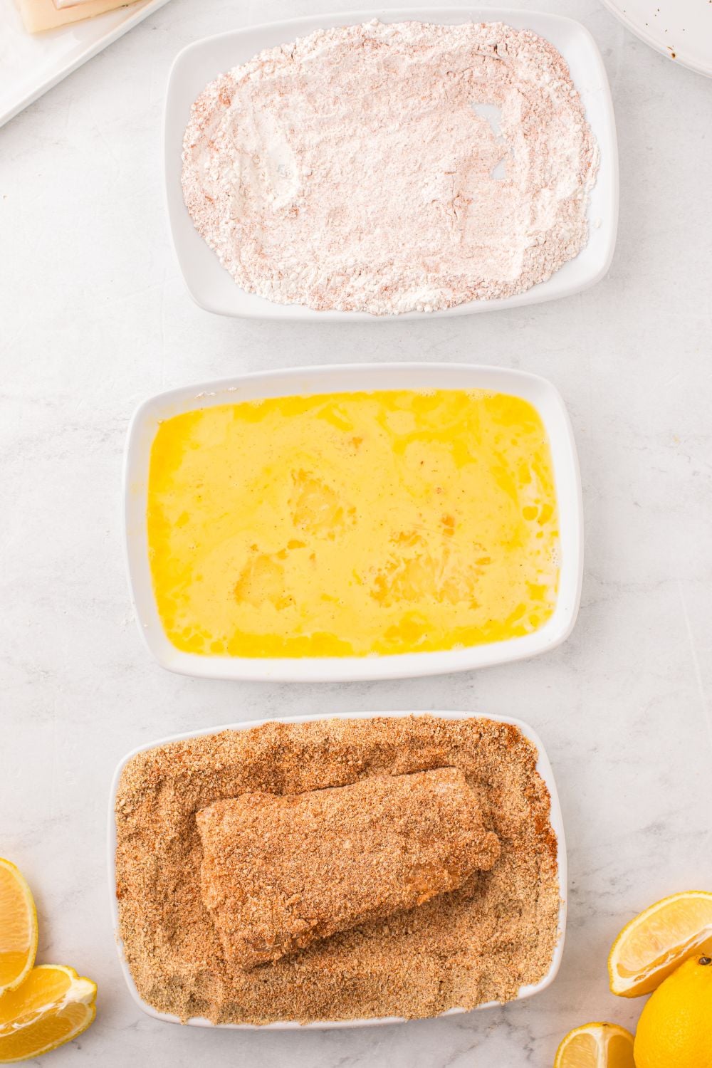 dredging fish in breadcrumbs in a bowl