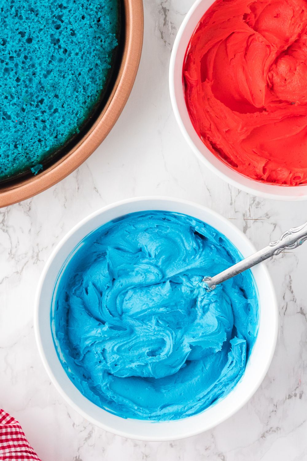blue frosting in a bowl with spoon on table 