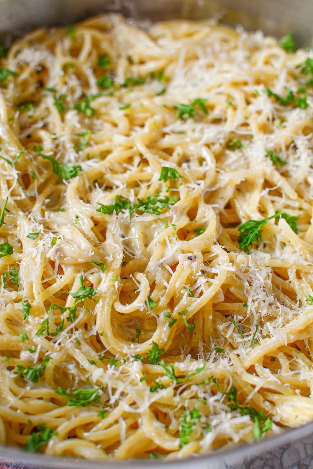 Garlic Parmesan Pasta in skillet with a close up view of noodles and cheese on top of pasta