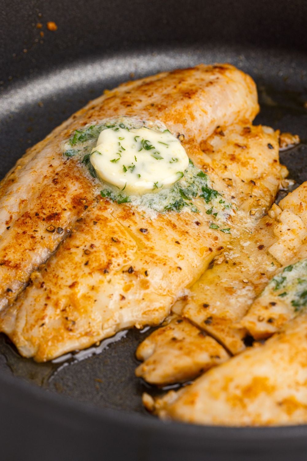 Pan Fried Tilapia in a skillet in a pan