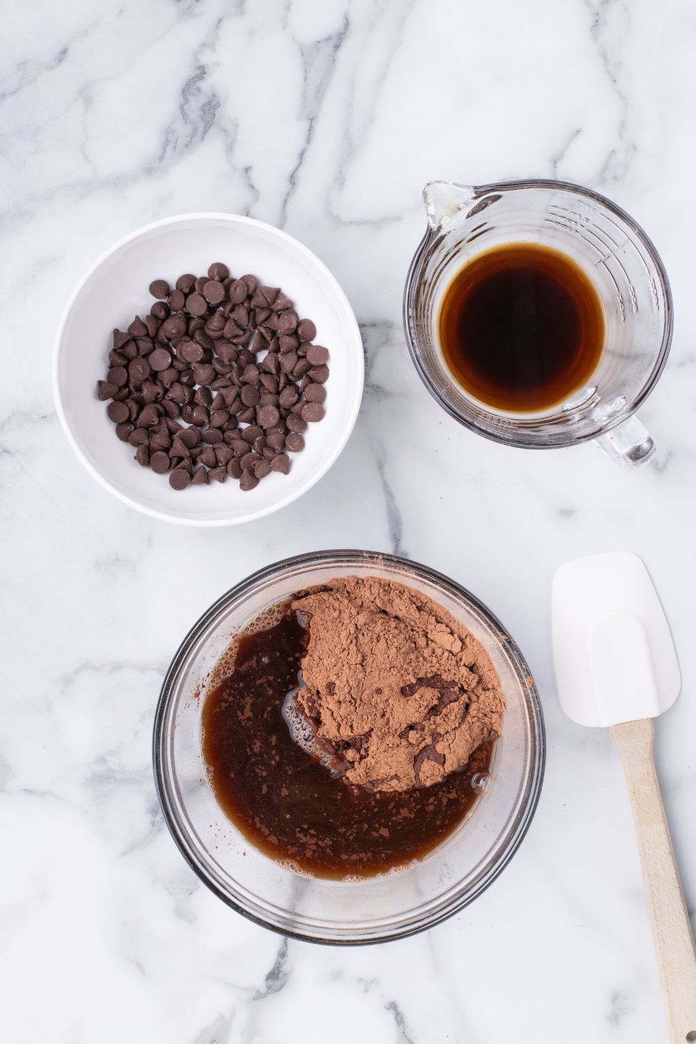 cake batter in bowl with a small bowl of chocolate chips and coffee next to it on table