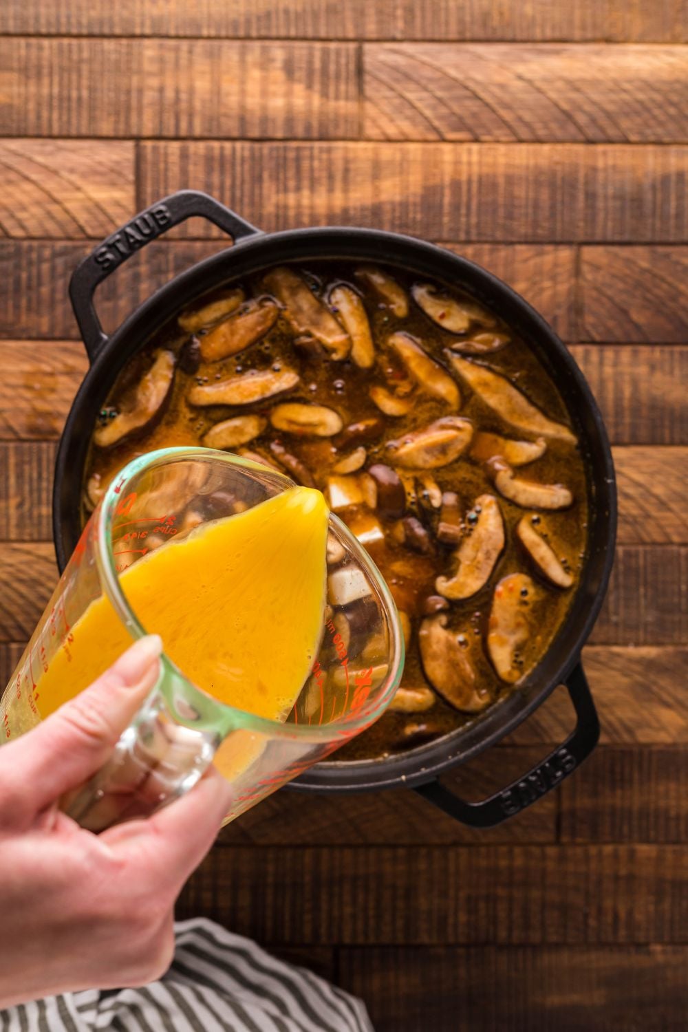 PF Changs Hot And Sour Soup being made in a pot with eggs pouring into soup