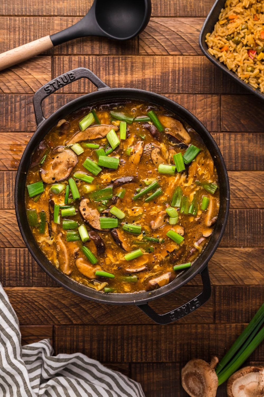 PF Changs Hot And Sour Soup in a pot on table with spoon and towel by it