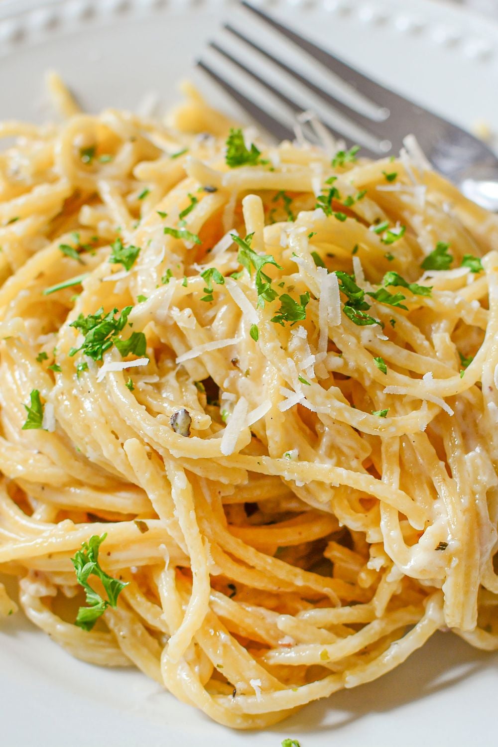 white plate with Garlic Parmesan Pasta and a fork to the side