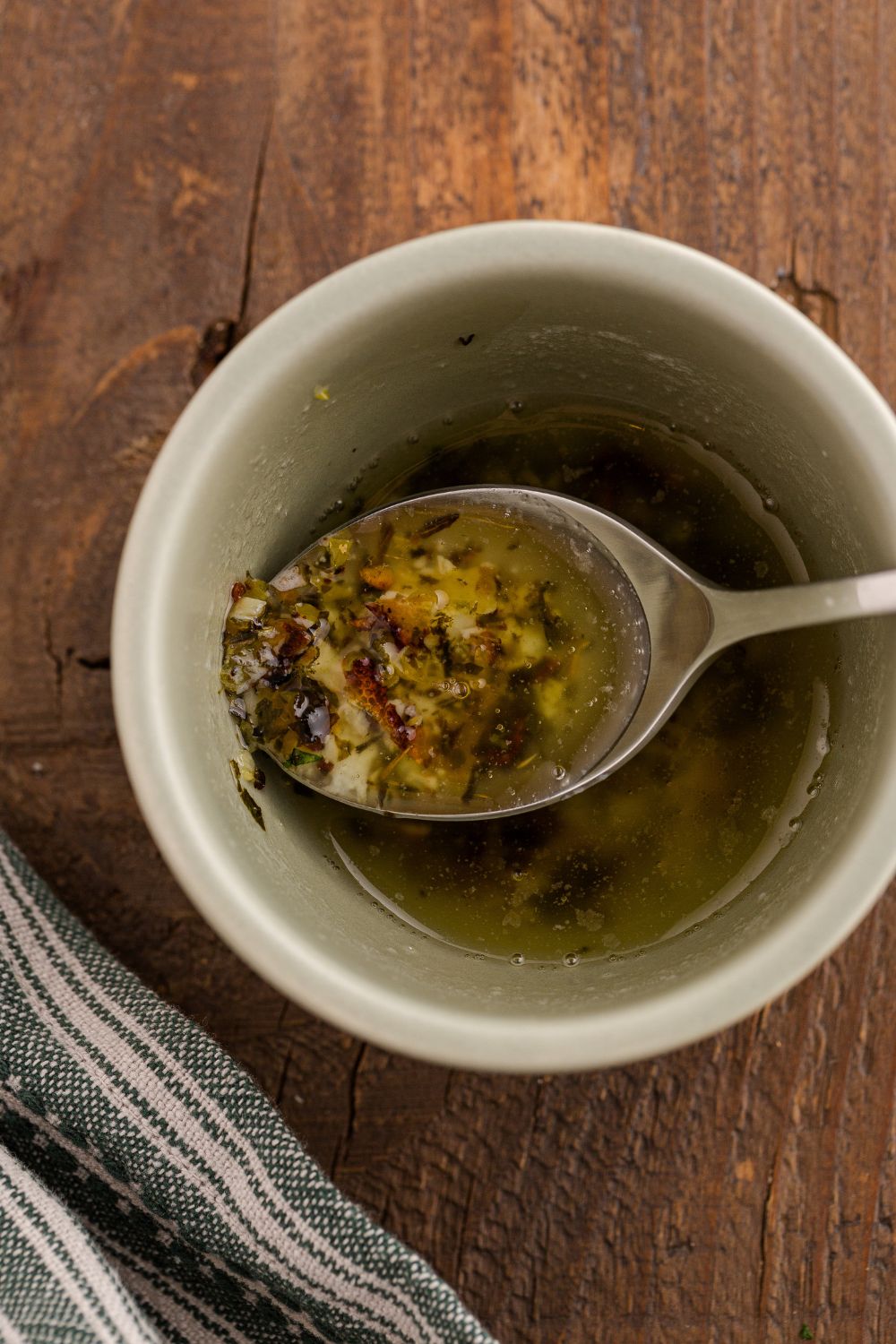 garlic mixture in a bowl with oil and a spoon in it