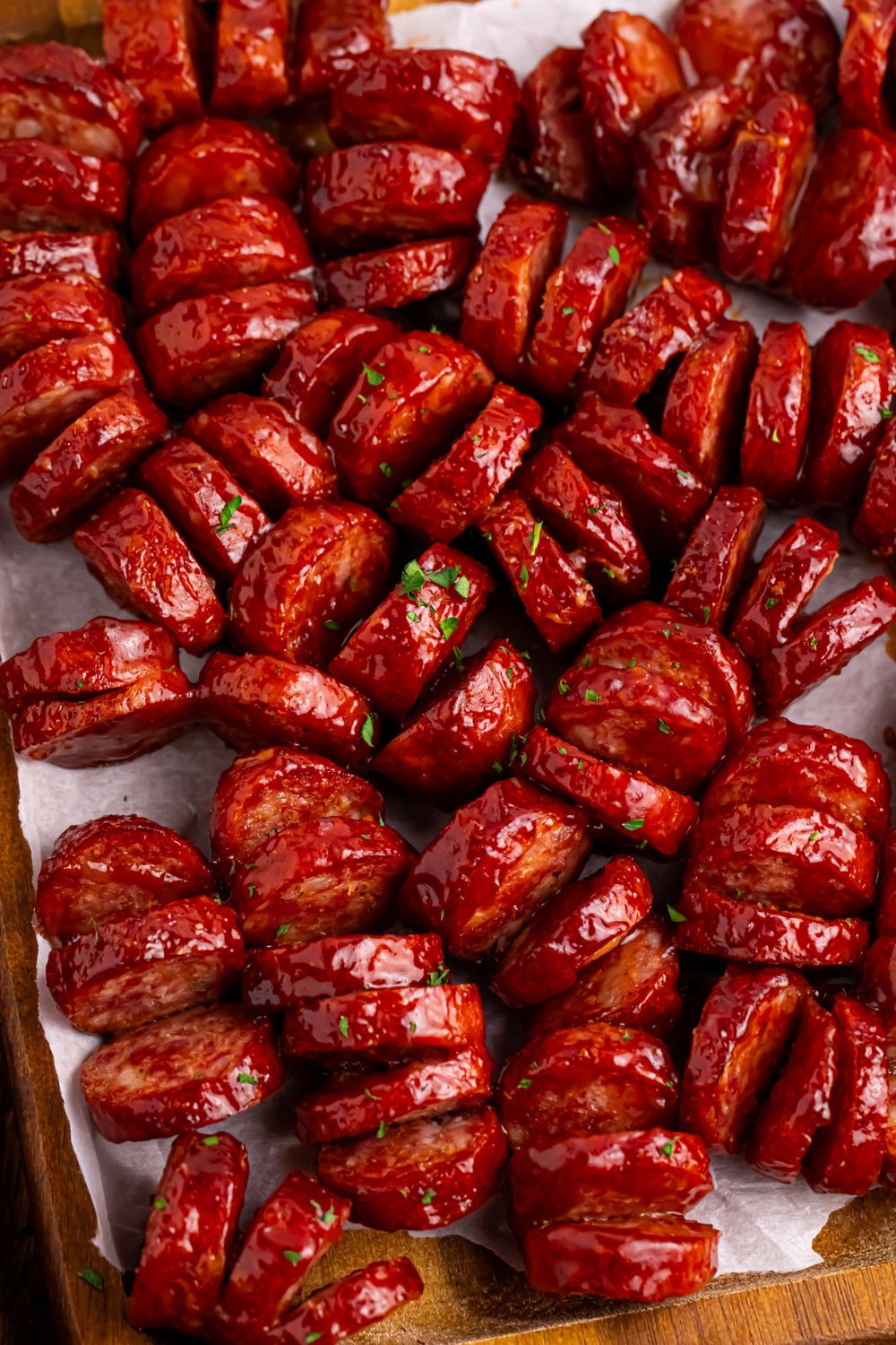 overhead view of BBQ Hasselback Smoked Sausages spread out with parsley sprinkled on top